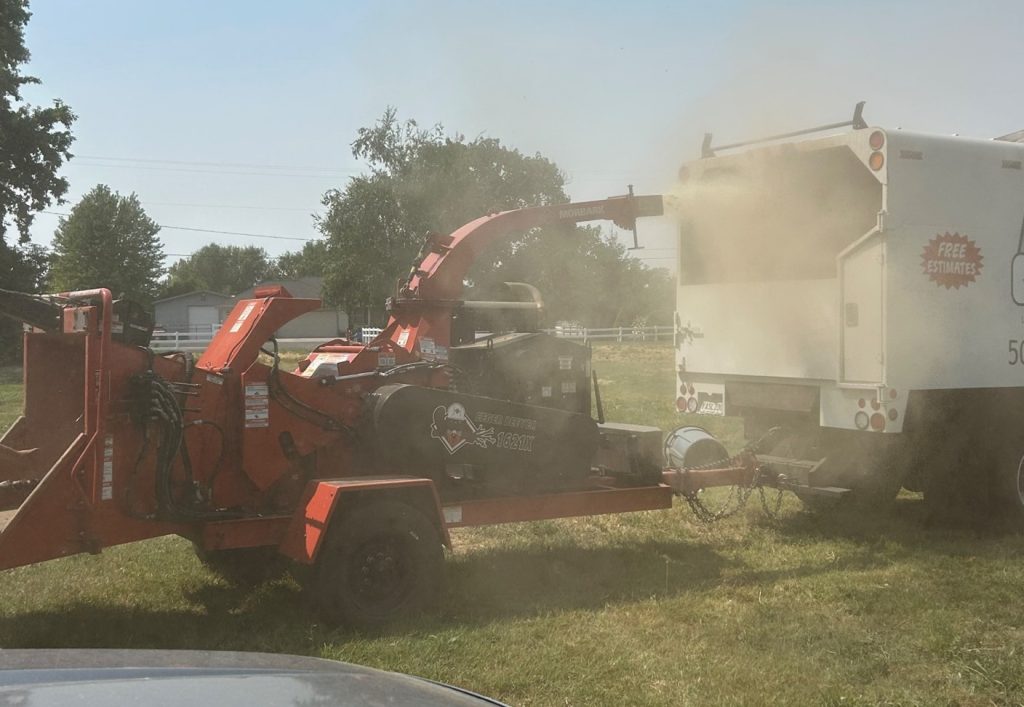 Image 1. Chipping process of apple orchard tear-out debris using Morbark, Eeger Beever, 1621” x 18”x 20.5” feeder throat with 140 horsepower motor.