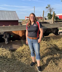 Leslie Johnson Standing in front of cattle on her farm.